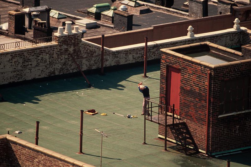 25 Мужчина играет в гольф на крыше одного из зданий Манхеттена.