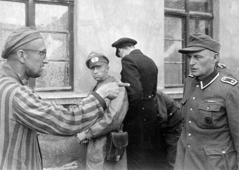 19 Выживший русский солдат идентифицирует бывшего охранника концлагеря Бухенвальд в Тюрингии, жестоко избивавшего заключенных, 14 апреля 1945 года, Германия.