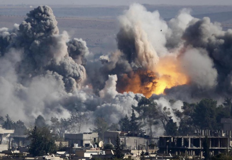 3 Kai Pfaffenbach. Smoke rises over Syrian town of Kobani after an airstrike, October 18, 2014.
