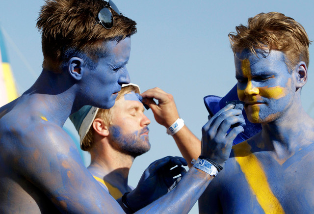 Шведские болельщики разукрашивают друг друга около НСК «Олимпийский» в Киеве, Украина. Швеция проиграла свой первый матч на «Евро-2012». (Anatolii Stepanov/Reuters)