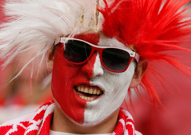 Разукрашенный польский болельщик ждет начала матча Польша-Россия на Национальном стадионе в Варшаве, Польша, 12 июня 2012 года. (Pascal Lauener/Reuters)