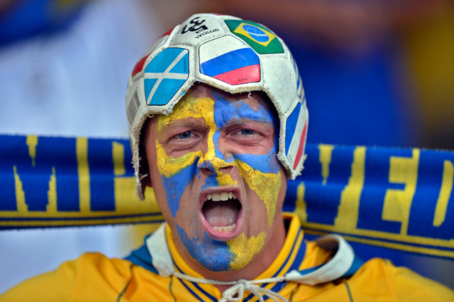 Шведский фан в самодельной шапке болеет за свою страну на матче между Украиной и Швецией, Киев, Украина, 11 июня 2012 года. (Martin Meissner/Associated Press)