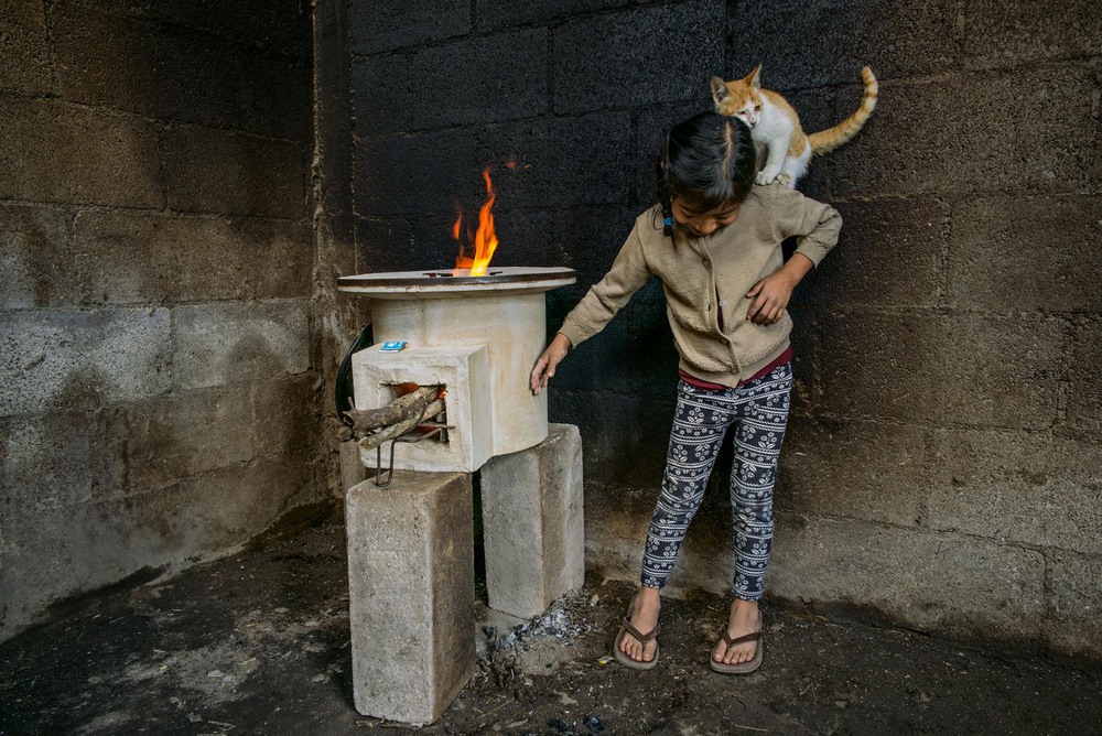 23 Автор: Линн Джонсон.
7-летняя Таня Лопес играет с кошкой в комнате с покрытыми сажей стенами из-за использования старого открытого камина.