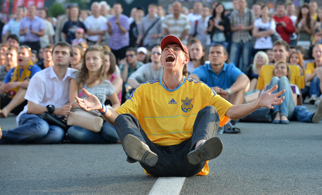 Украинские болельщики наблюдают за игрой Польши и России на большом экране в фан-зоне на площади Независимости, Киев, Украина, 8 июня 2012 года. (Sergei Supinsky/AFP/Getty Images)