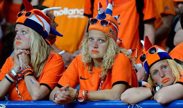 Удрученные голландские фаны грусно смотрят в камеру после матча Между Голландией и Данией, Харьков, Украина, 9 июня 2012 года. Их команда проиграла Дании со счетом 1-0. (Geert Vanden Wijngaert/Associated Press)