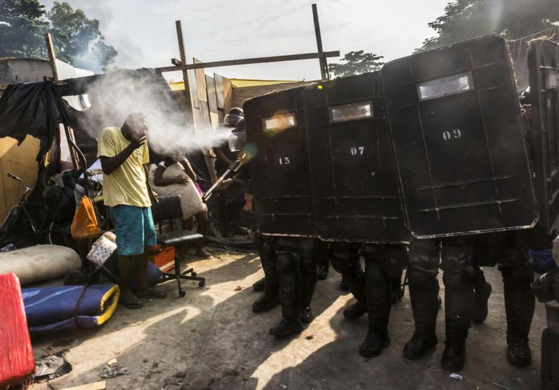 14 Ana Carolina Fernandes. Riot police use pepper gas against residents of the Telerj slum as they attempt to repossess the land in Rio de Janeiro, April 11, 2014.
