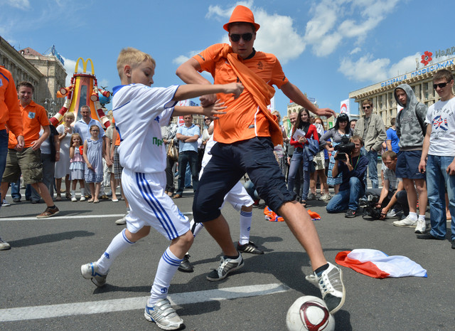 Голландский фан (справа) играет в футбол с украинский мальчиком в фан-зоне на площади Независимости в Киеве, Украина. Футбол - сближает людей!