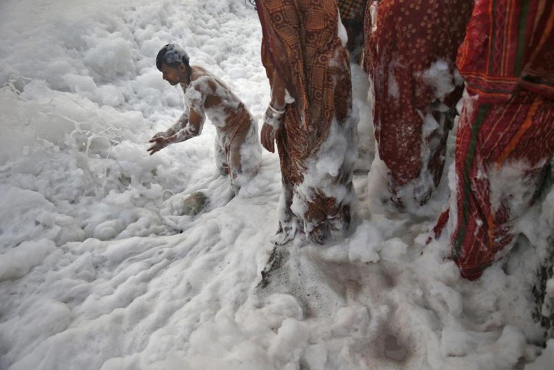 23 Ahmad Masood. A Hindu devotee worships in the polluted waters of the river Yamuna during the Hindu religious festival of Chatt Puja in New Delhi, October 30, 2014.