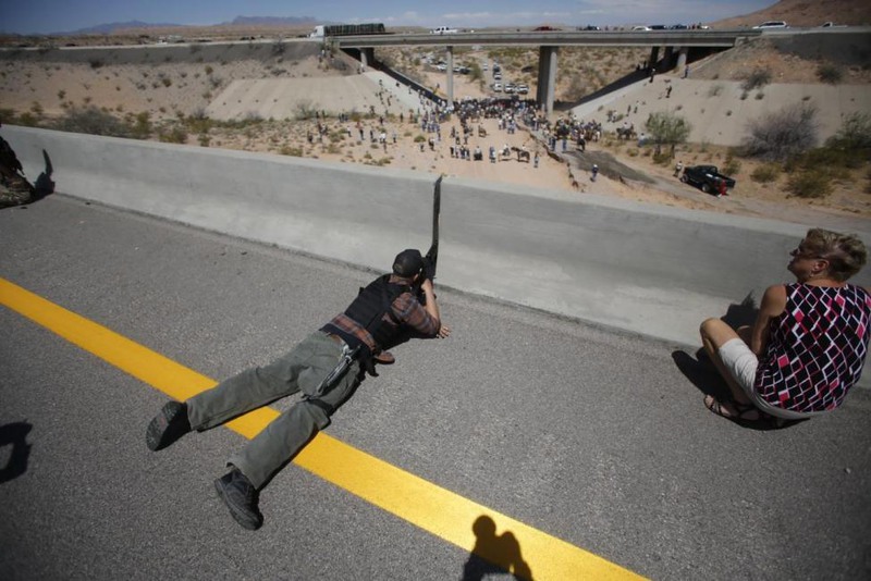 26 Jim Urquhart. Eric Parker from central Idaho aims his weapon from a bridge as protesters gather by the Bureau of Land Management's base camp, where cattle that were seized from rancher Cliven Bundy are being held, near Bunkerville, Nevada, April 12, 2014.