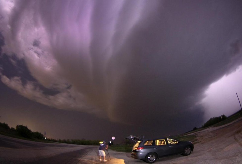28 Gene Blevins. A large tornadic vortex signature thunderstorm supercell passes over storm chaser Brad Mack in Graham, Texas, April 23, 2014