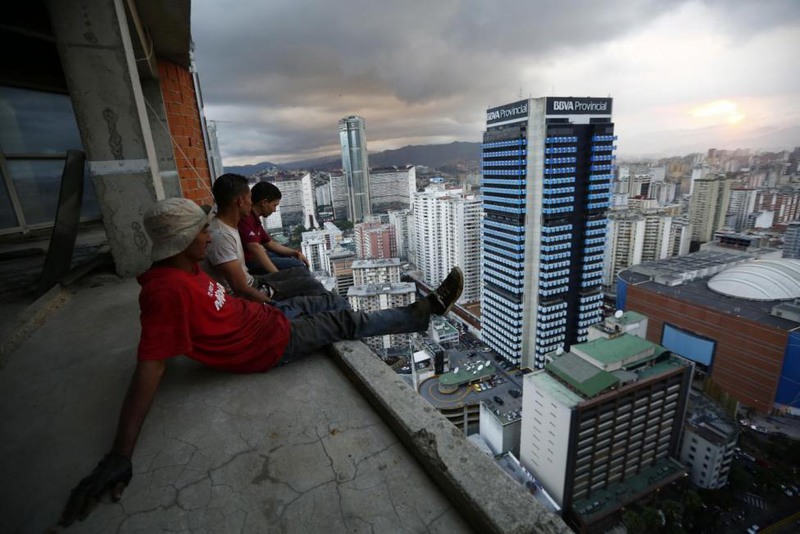 29 Jorge Silva. Men rest after salvaging metal on the 30th floor of the "Tower of David" skyscraper in Caracas, February 3, 2014.