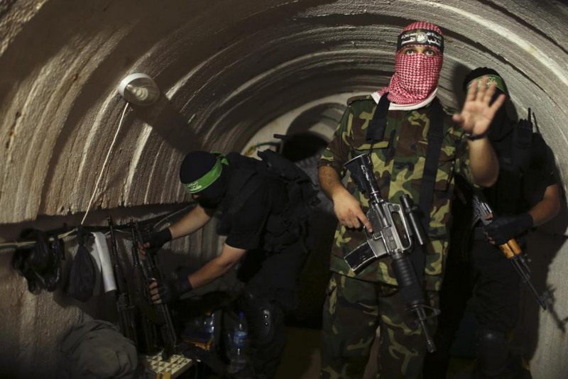 32 Mohammed Salem. A Palestinian fighter from the Izz el-Deen al-Qassam Brigades, the armed wing of the Hamas movement, gestures inside an underground tunnel in Gaza, August 18, 2014.