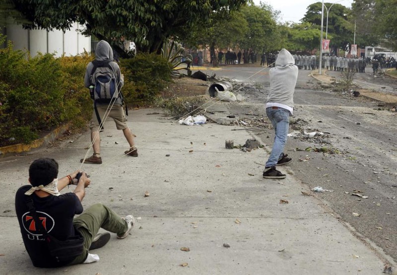 33 Carlos Garcia Rawlins. Demonstrators use a slingshot against the National Guard during a protest in San Cristobal, February 27, 2014.
