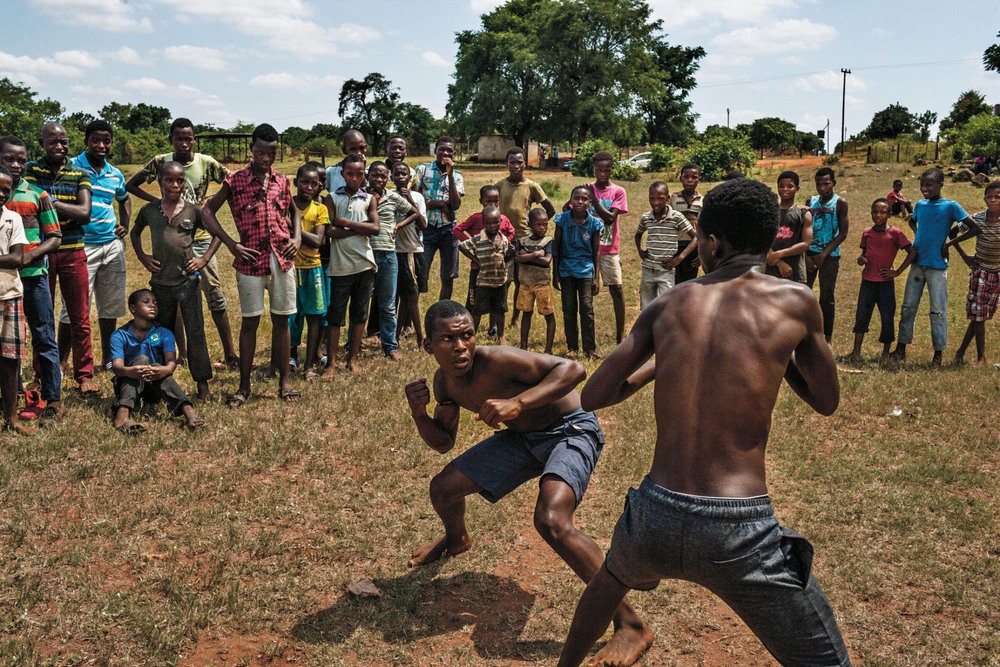 46 Автор: Пит Мюллер.
Беспощадный кулачный бой мальчишек из народа венда в Южной Африке. Эта традиционная борьба называется мусангве. Для мальчиков от девяти лет это способ выплеснуть мужскую энергию и проверка на агрессию. Взрослые наблюдают за боями, чтобы сдержать насилие.