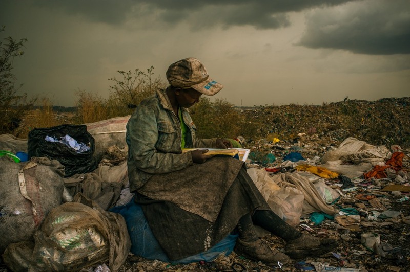 «На свалке Дандора». Фотограф - Мика Алберти (США). 
1 место в категории «Проблемы повседневности». 
На фото женщина, занимающаяся сбором мусора на 30-акровой свалке: хотела бы больше времени, чтобы почитать попадающиеся книги.