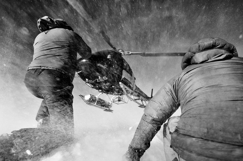 14. Два человека помогают посадить вертолет на вершине горы Гонда, в швейцарских Альпах. Автор - Philip Field.