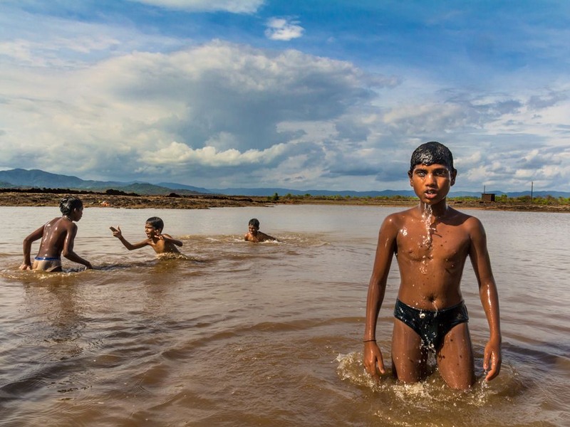 26 Подростки купаются в озере, которое увеличилось в размере после недели сильных ливней в Кумте. Индия. Автор - Dinesh Hegde.