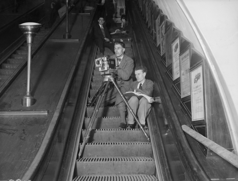 17. Британский режиссер Энтони Асквит (1902-1968), справа, снимает свой &#8203;&#8203;новый фильм "Подземка" на эскалаторе в метро, май 1928 г.