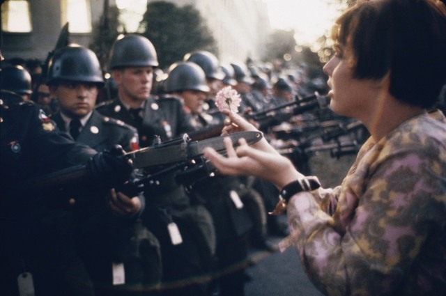 Молодой пацифист Джейн Роуз Кэсмир обращается с цветком в руках к охранникам в Пентагоне. Протест против войны во Вьетнаме, 1967 год.