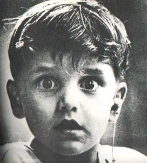 Ребенок Гарольд Виттльз впервые в своей жизни слышит. Доктор только что установил ему слуховой аппарат.