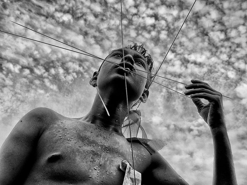 19 "Пирсинг для верующего". Человек пронизывает свое лицо во время фестиваля Чарак Пуджа в Западной Бенгалии (Индия). Автор - Avishek Das.