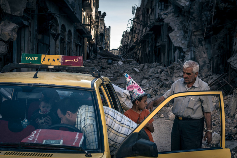 18 Abu Hisham Abdel Karim with his family in the Khalidieh district, which had been destroyed by fighting.
Sergey Ponomarev for The New York Times. HOMS, SYRIA
06/15/014