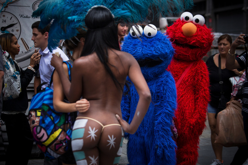 21 Costumed characters in Times Square checked out the competition, a group clad in swimwear and body paint.
Damon Winter/The New York Times. MANHATTAN
07/29/2014