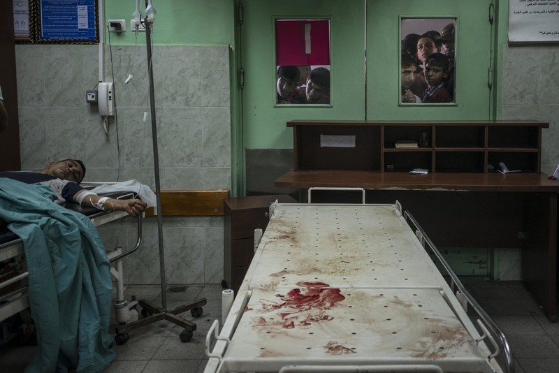 23 Relatives looked into a hospital’s operating room at those injured in an Israeli airstrike nearby.
Sergey Ponomarev for The New York Times. BEIT LAHIYA, GAZA STRIP
07/24/2014