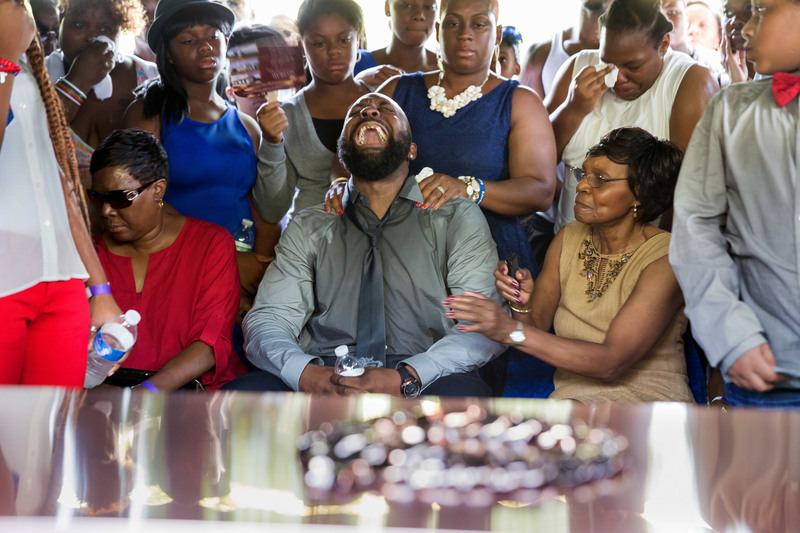 30 Michael Brown Sr. with other mourners as his son’s coffin was lowered into the ground at St. Peter’s Cemetery.
Richard Perry/The New York Times