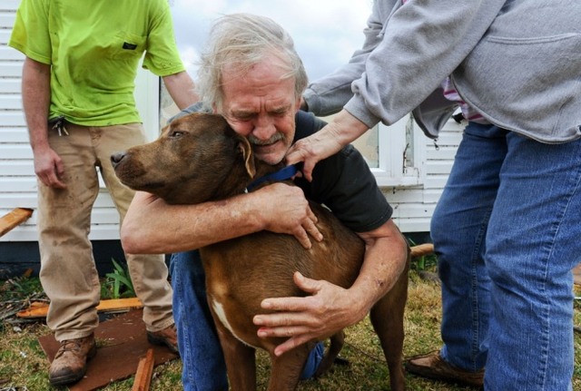 Грег Кук обнимает свою собаку, которую удалось найти после Торнадо. Алабама, март 2012 г.