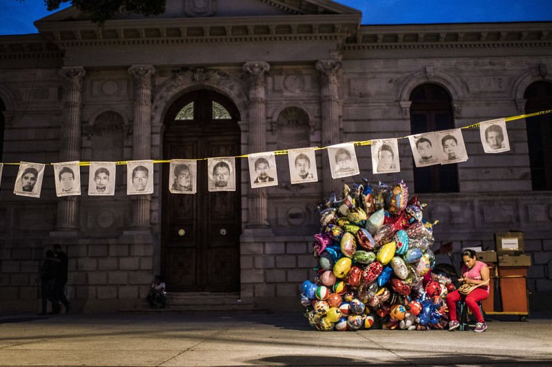 41 Beneath portraits of the missing students believed to have been killed by a local gang, a woman sold balloons for the Day of the Dead.
Sebastian Liste/Noor. CHILPANCINGO, MEXICO
10/31/2014