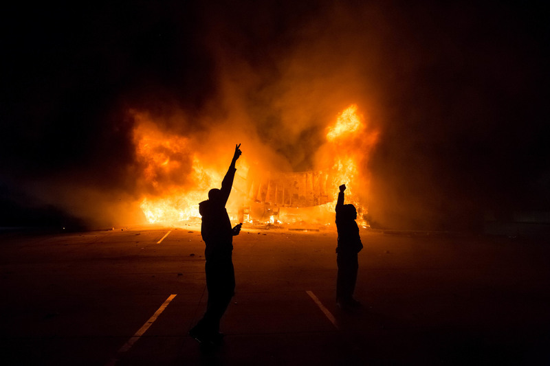 46 After a grand jury decided not to indict Darren Wilson in the killing of Michael Brown, demonstrators stood before a burning AutoZone.
Whitney Curtis for The New York Times. DELLWOOD, MO.
11/25/2014
