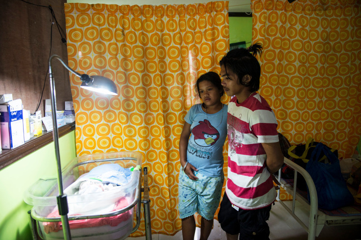 7. Analyn Pesado и Ryan Bacate наблюдают за своим новорожденным малышем в  клинике Толоса. (Таклобан, Филиппины).