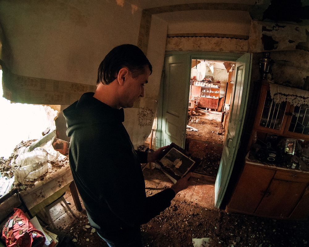 2. м. Макарів і мій товариш Вячеслав Кириленко з фотографією своїх молодих батьків у їхньому зруйнованому будинку.