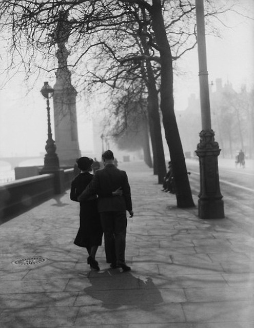 2. a loving couple stroll along the embankment, london, in the sunshine on the first day of spring with their arms round each other, 1935.