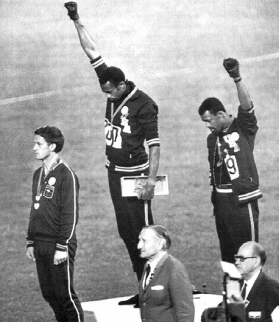 Афроамериканские атлеты Томми Смит и Джон Карлос поднимают кулаки в жесте солидарности. Олимпийские Игры, 1968 год.