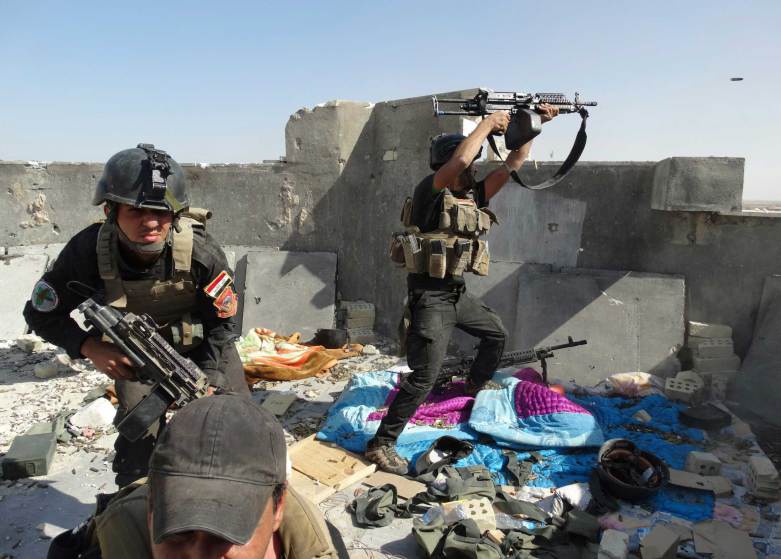 23  Автор - REUTERS. Members of the Iraqi Special Operations Forces take their positions during clashes with the al Qaeda-linked Islamic State of Iraq and Syria (ISIS) in the city of Ramadi, June 19, 2014.