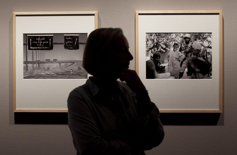 1 Associated Press photographer Anja Niedringhaus stands next to photographs from Iraq, left, and Afghanistan, right, during a press preview of her exhibition "Anja Niedringhaus At War" at the Gallery C/O in Berlin on September 9, 2011. (Photo/Markus Schreiber)