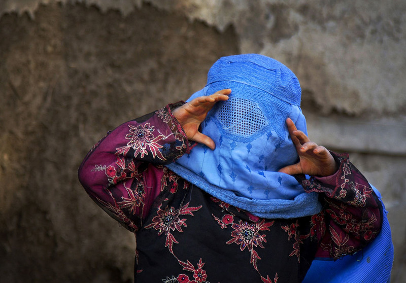 2 An Afghan girl tries to peer through the holes of her burqa as she plays with other children in the old town of Kabul, Afghanistan, on April 7, 2013. (AP Photo/Anja Niedringhaus)