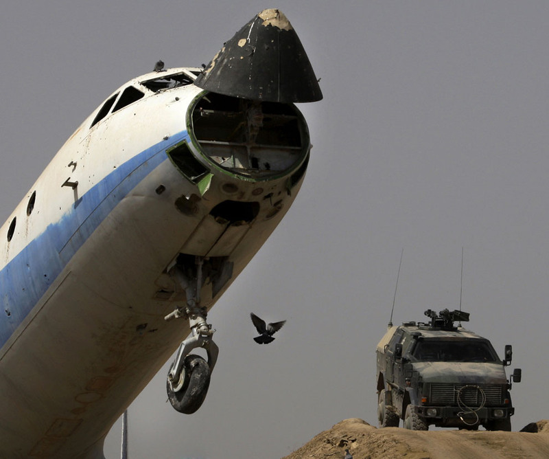 4 German ISAF soldiers secure an airfield next to a destroyed passenger plane left by the Russians in Kunduz on September 19, 2008. (AP Photo/Anja Niedringhaus)