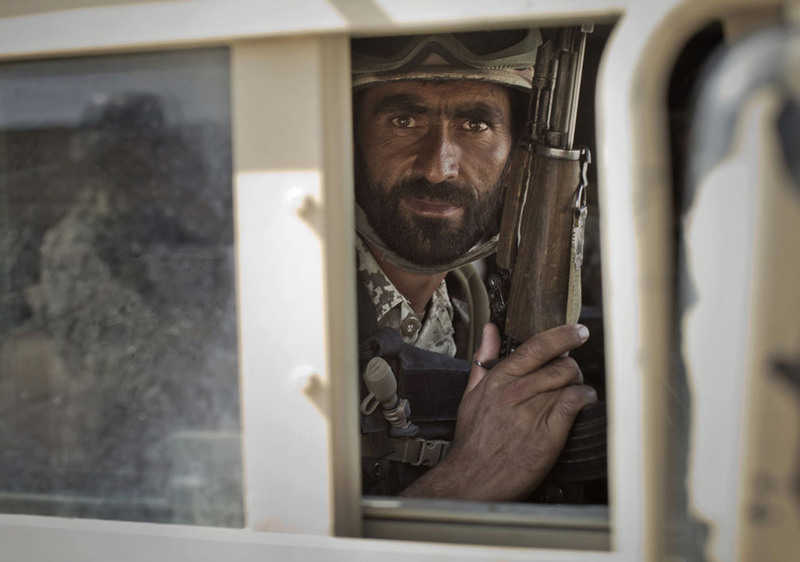 5 A member of Afghanistan's elite Civil Order Police looks through a window of his armored vehicle during a patrol in Marjah, southern Helmand province, on October 19, 2012. (AP Photo/Anja Niedringhaus)