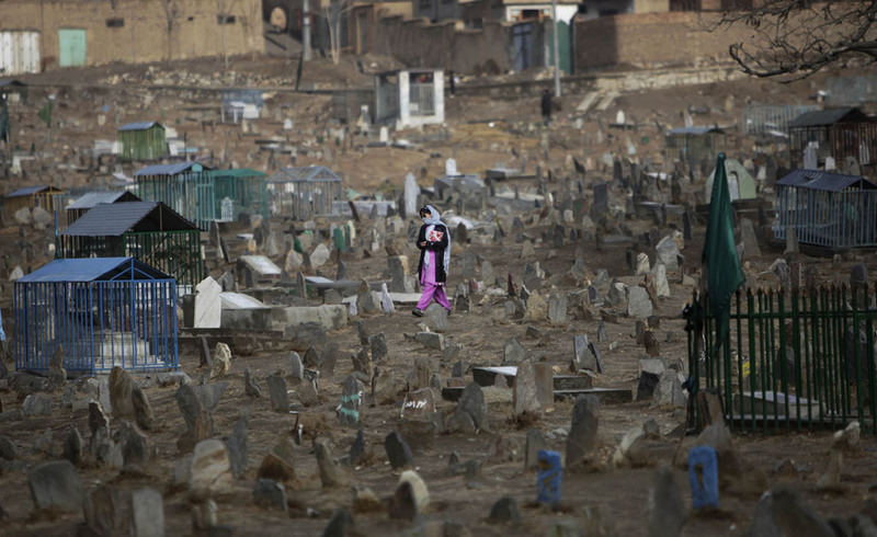 12 An Afghan girl crosses a cemetary in the outskirts of Kabul on November 25, 2009. (AP Photo/Anja Niedringhaus)