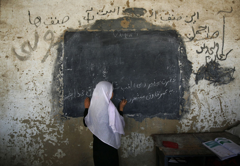 14 An Afghan girl writes on a board in front her class at the girls high school Ayeshe Sedeqa in the center of Kunduz, northern Afghanistan, on September 21, 2008. The Afghan government alleges the Taliban tried to poison students at girls' schools, causing outbreaks of sickness, and says 15 suspects were arrested. (AP Photo/Anja Niedringhaus)