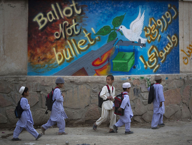 23 School children pass by a painted sign reading, "ballot not bullet" on their way back home on the outskirts of Kandahar, on March 12, 2014. Warlords with a violent past have played a role in influencing Afghan politics since a U.S.-led coalition helped oust the Taliban in 2001. But they are emerging to play an overt political role in next month's presidential elections as President Hamid Karzai leaves the scene. (AP Photo/Anja Niedringhaus)