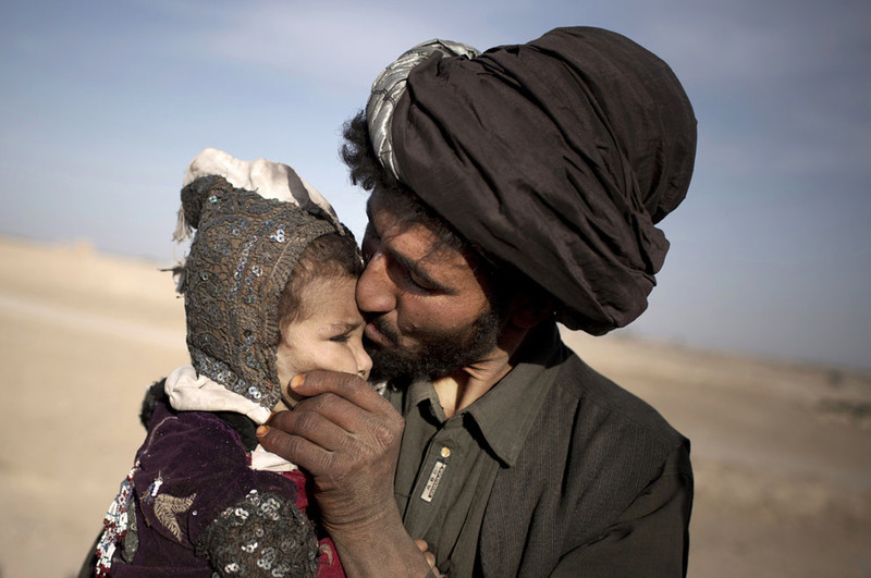 29 An Afghan nomad kisses his young daughter while watching his herd in Marjah, Helmand province, on October 20, 2012. In southern Helmand province, one of Afghanistan's deadliest battlefields, angry residents say 11 years of war has brought them widespread insecurity. They say they are too afraid to go out after dark because of marauding bands of thieves and during the day corrupt police and government officials bully them into paying bribes. Development that was promised hasn't materialized and the Taliban's rule is often said to be preferred. (AP Photo/Anja Niedringhaus)