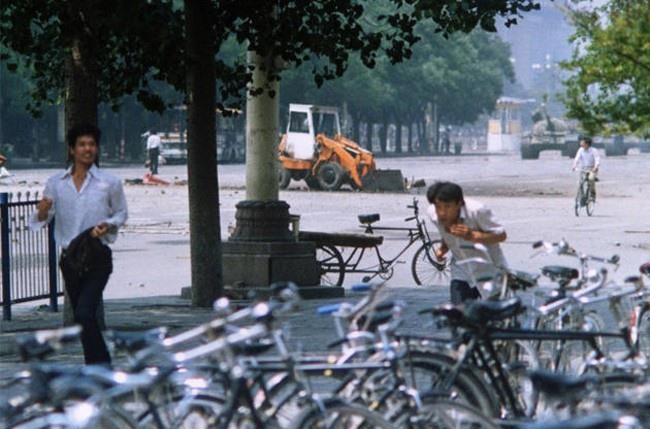 4. В верхнем левом углу неизвестный человек стоит без оружия перед колонной танков. 1989 год. Источник: Pinterest.