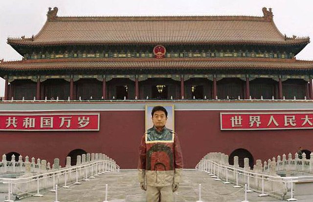 Лиу на площади Тяньаньмэнь в Пекине. Его лицо «заменило» лицо председателя Мао.
