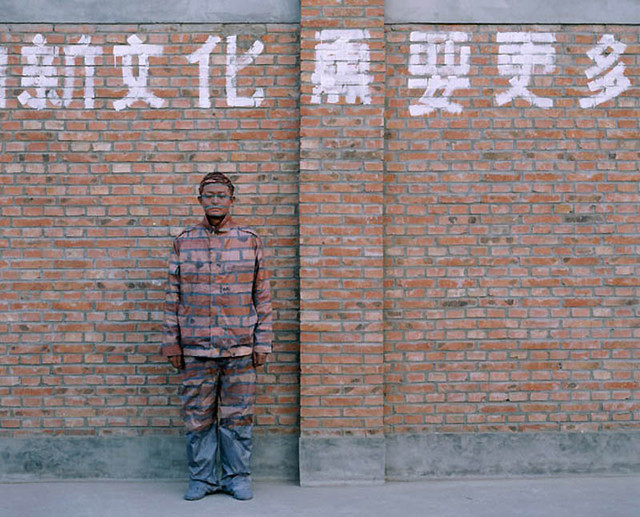Лиу Болин позирует для фото перед старым районом художников в 2006 году в поселке Суочжи, Китай.