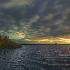 Похмурий вечір на Дніпрі розпружився палахкотливими бризьками світла над обрієм.