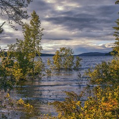 Сонце заходить, води темніють на озері в Лапландії влітку після дощів і повені.